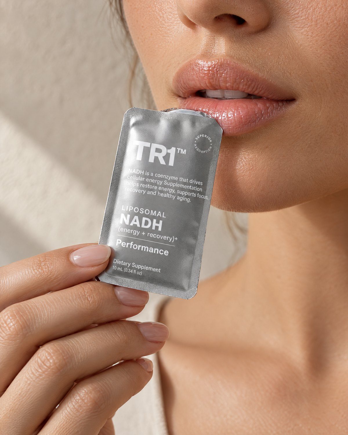 Woman holding a TR1 liposomal NADH sachet to her lips