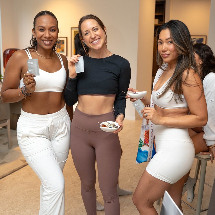 Three women holding TR1 sachets